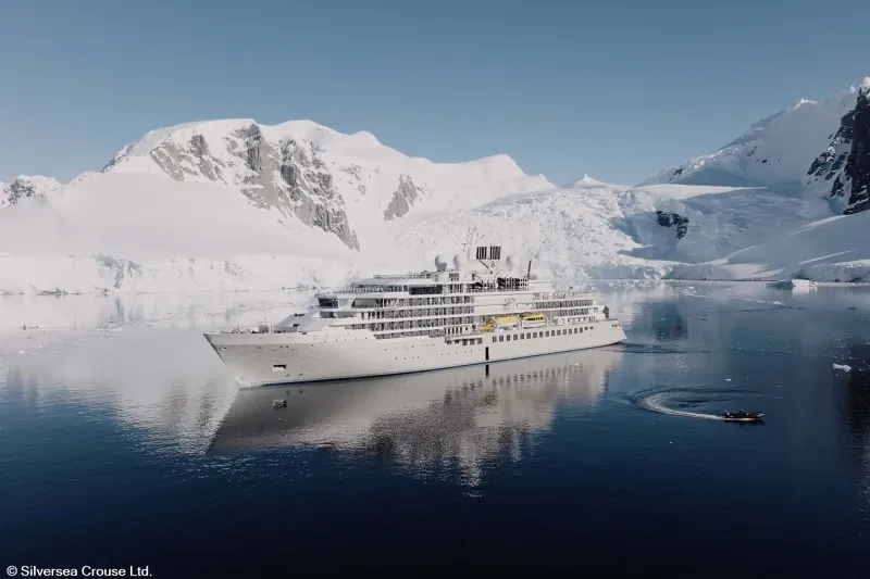 Das Expeditionsschiff Silver Endeavour von Silversea in einer Bucht vor verschneiten Bergen der Antarktis